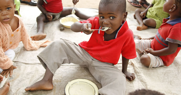 A young Malawi boy eats a snack. Photo credit: Megan Collins, Catholic Relief Services.