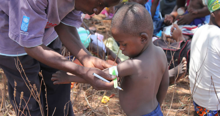 A village health worker checks a child's Mid-Upper Arm Circumference USAID in Zimbabwe