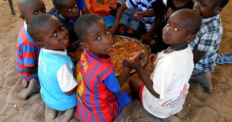 Children eat a hearty lunch provided for them at a farmer training in Senegal.