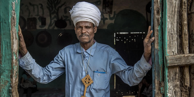 Banner image of an Ethiopian religious leader standing in a doorway. Photo credit: Karen Kasmauski/MCSP.