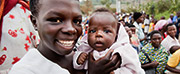 Photo of woman holding a baby and smiling