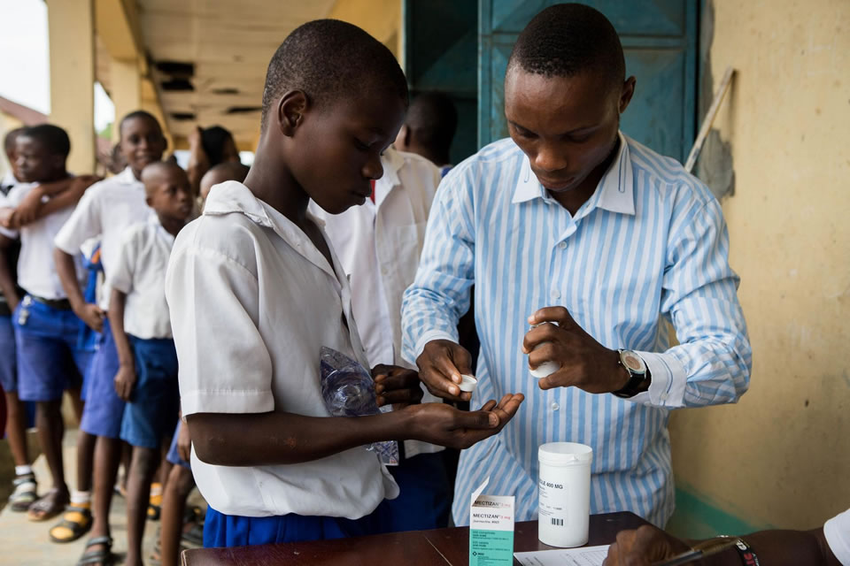 Two Nigerian students receive medicine for NTDs. Photo credit: Ruth McDowall for RTI International.