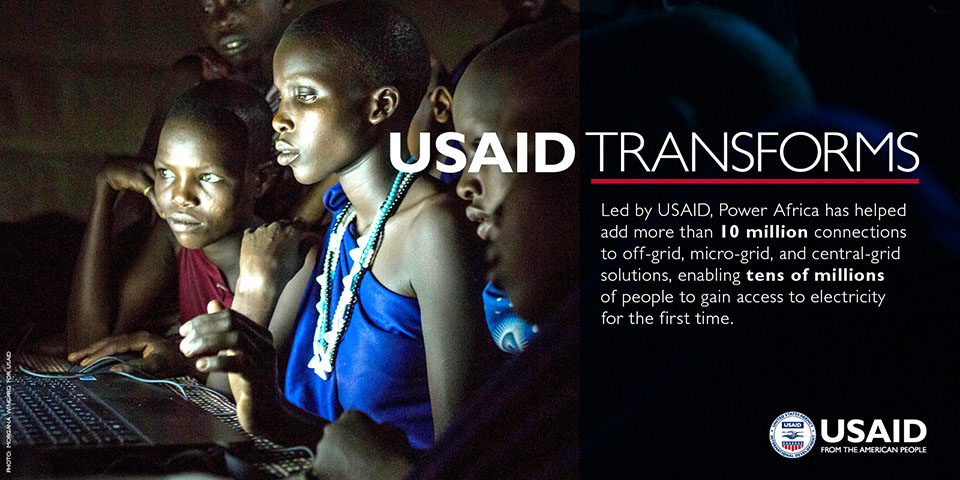 Photo of a group of women at a computer screen. Text states: USAID Transforms. Led by USAID, Power Africa has helped add more than 10 million connections to off-grid, micro-grid and central-grid solutions, enabling tens of millions of people to gain access to electricity for the first time.