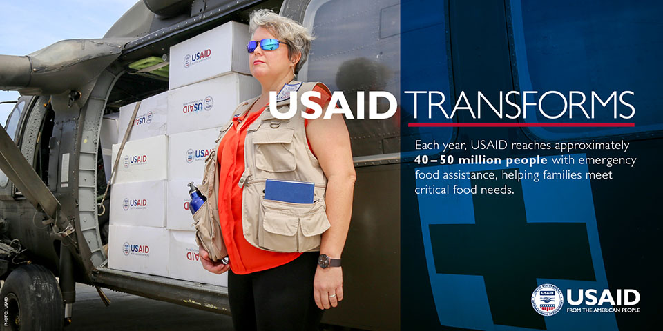Photo of an aid worker next to helicopter. USAID Transforms. Each year, USAID reaches approximately 40-50 million people with emergency food assistance, helping families meet critical food needs.