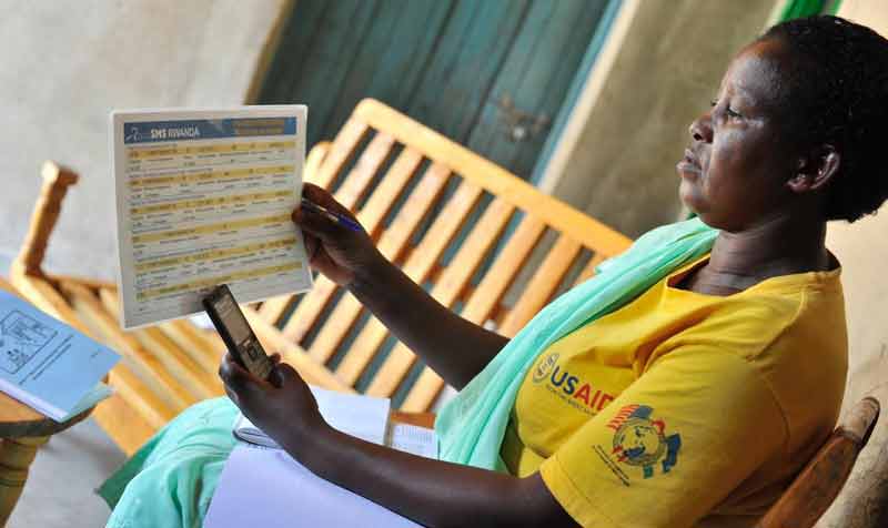 At the end of her visit, Community Health Worker Athalia Mukamusoni sends the health information she collected to a national dashboard that keeps track of mother and children's health at the community level. 