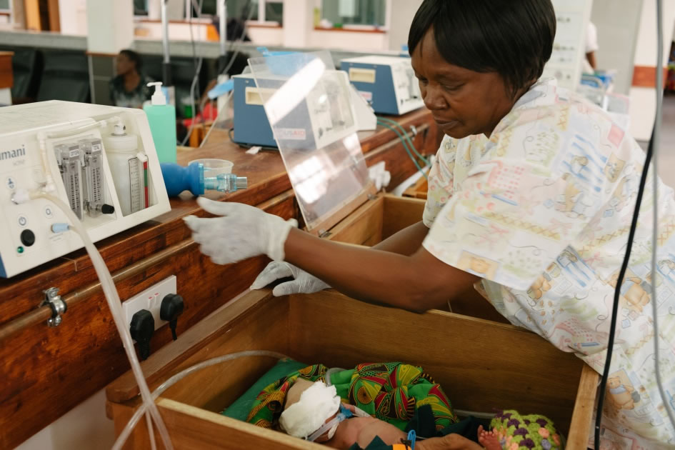 A health worker cares for a premature infant in a hospital. Photo credit: Dave Cooper for USAID.