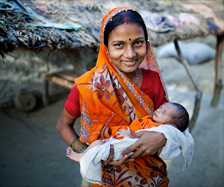 Smiling woman from India holding her baby