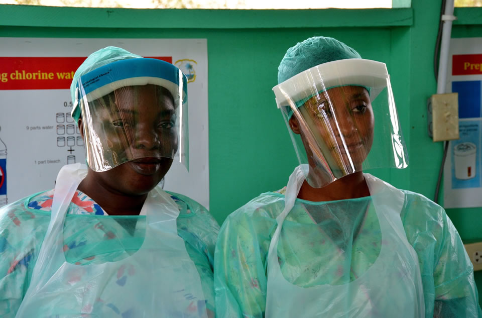 Photo of two female health workers in the DRC wearing protective suits. 