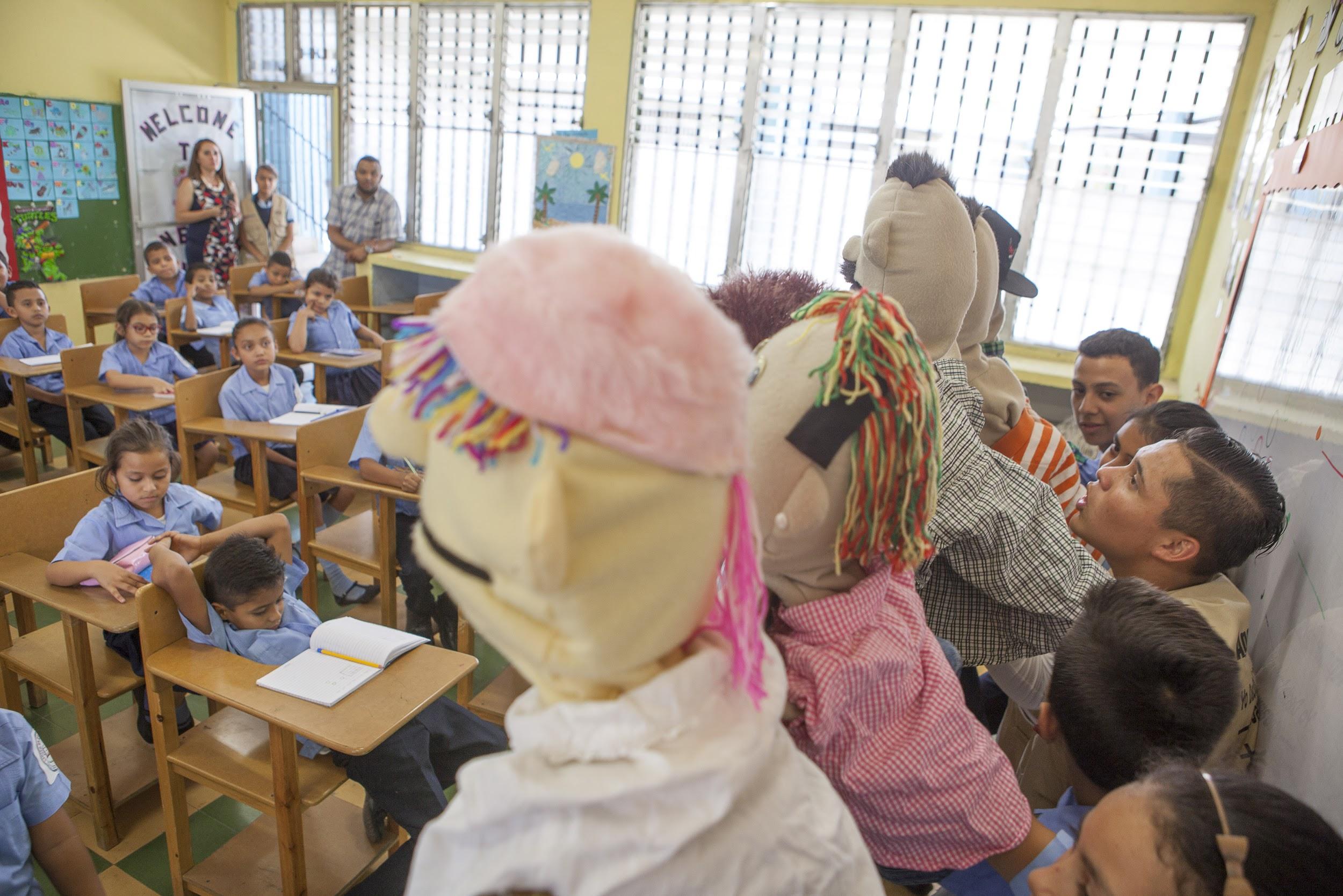 Student leaders at the Juan Molina Educational Center in Tegucigalpa, Honduras, use puppets to teach younger children about the Zika virus. 
