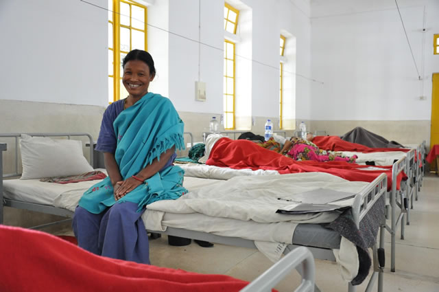 Photo of Juliana sitting on a bed in a Bangladeshi hospital. Photo credit: Amy Fowler/USAID