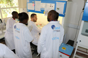A researcher trains lab technicians in Uganda.