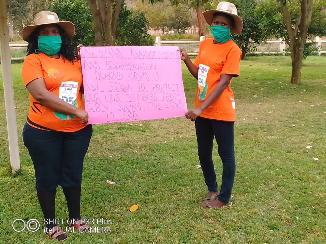 Two DREAMS Ambassadors hold a sign to raise awareness about the rising issue of GBV in their community due to COVID-19 lockdowns. / FHI360, Zimbabwe