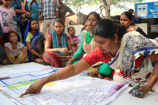 In India, a woman points to an area on a map