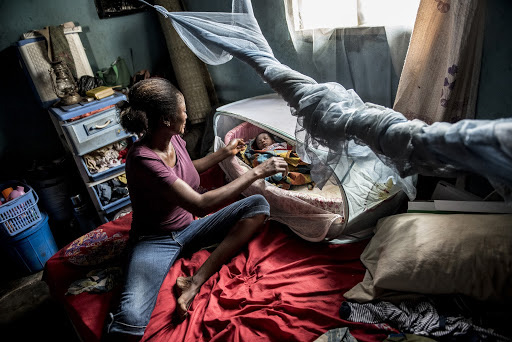 A woman provides care for an infant with malaria in Nigeria