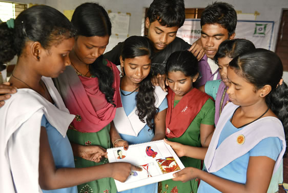A group of young students examine health information. Photo credit: Prasanta Biswas/Photoshare