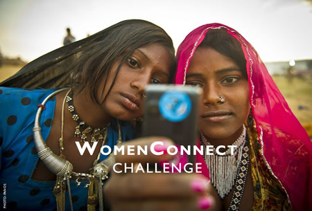 Photo of two young women using a cell phone. Photo credit: PANOS