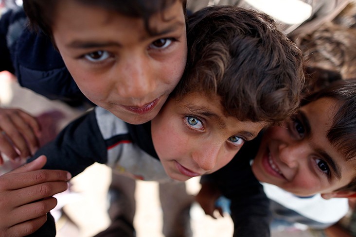 Displaced Iraqi children, who fled the violence in the northern city of Mosul as a result of a planned operation to retake the city from jihadists, pose for the camera at the Hasan Sham camp on March 26, 2017, in the village of Hasan Sham, some 30 kilometres east of Mosul.