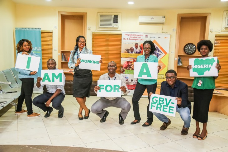 USAID staff in Nigeria hold up signs saying they are working for a GBV-free country.