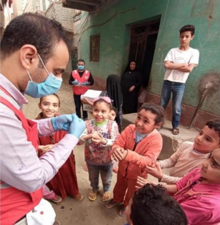 An Egyptian Red Crescent worker demonstrates effective hand-washing techniques to children.