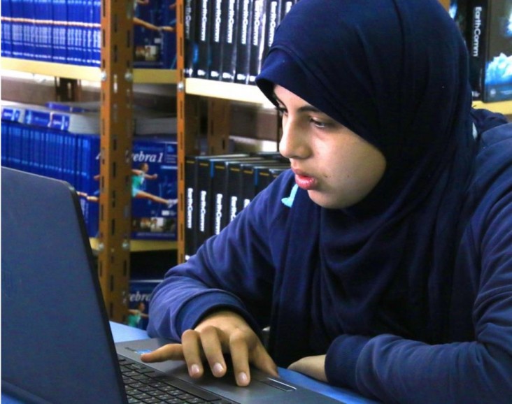 A STEM high school student works on her laptop.