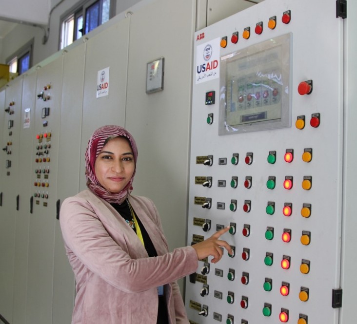 Water pump station manager stands at controls 