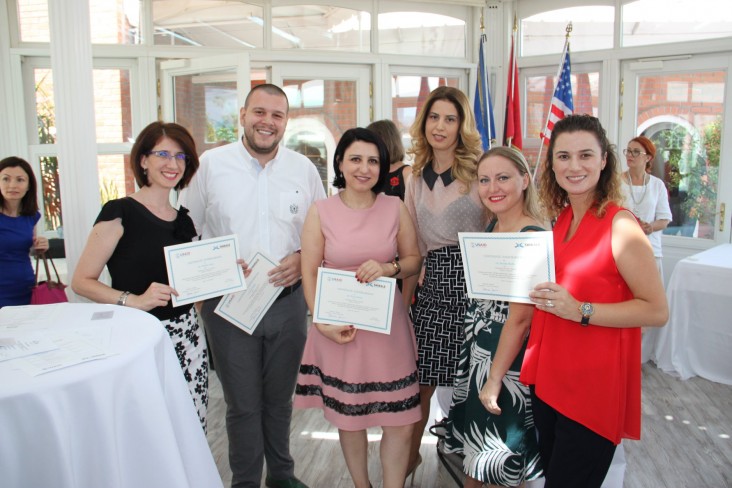 Young adults pose with USAID certificates