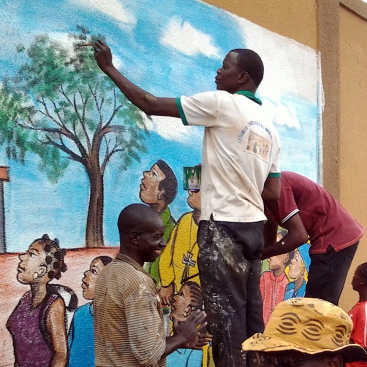 A group of youth in Burkina Faso painting a mural in their community
