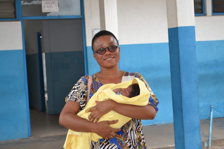 Woman carrying an infant .