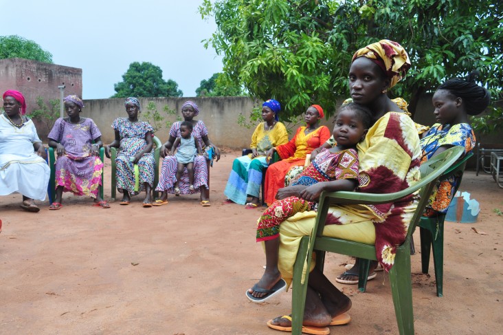Women and children gather at a community health group meeting