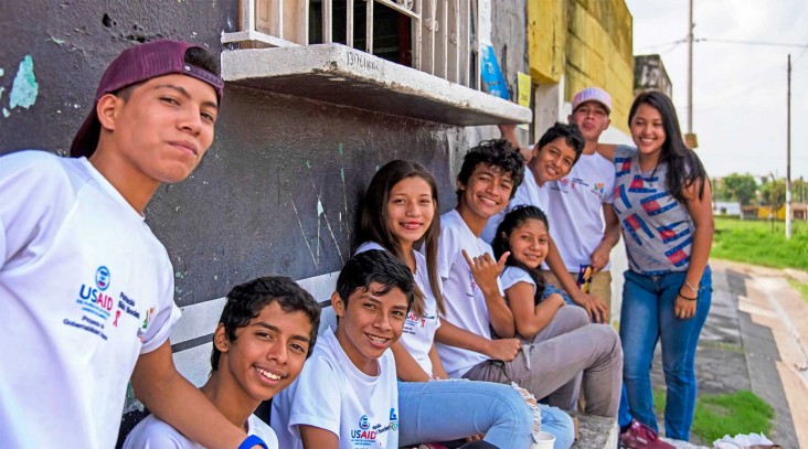 A row of smiling Guatemalan youths in USAID T-shirts