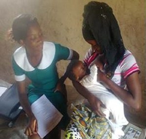 Madam Kusumi Gipi (right) practices proper positioning and attachment  during a breastfeeding counseling session with a local community health worker. 