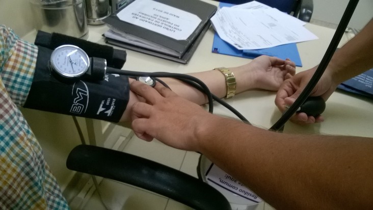 A doctor measures patient's blood pressure