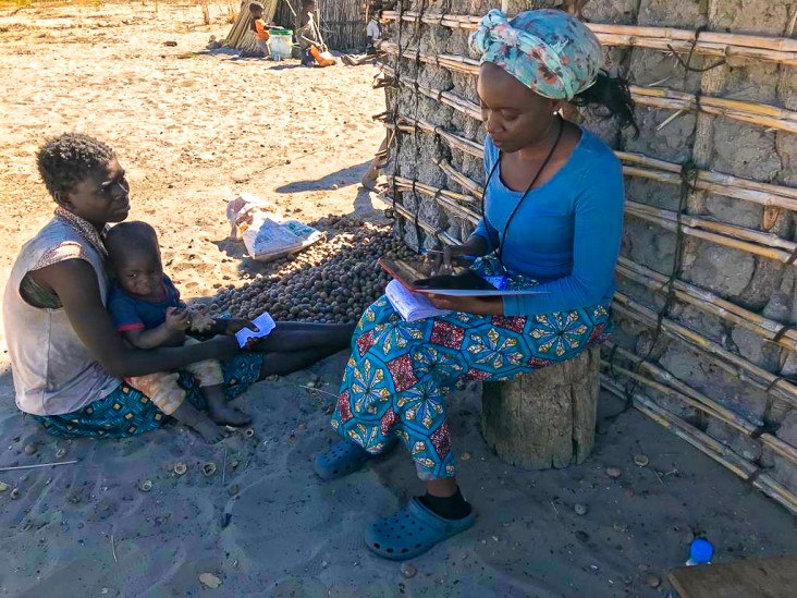 A field operator interviews a mother and child about their health and nutrition status.