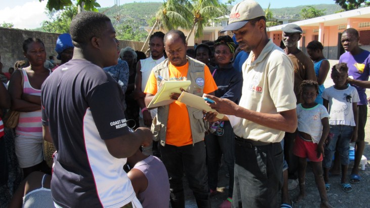 USAID/OFDA disaster consultants Ralph Simon (middle) and Marc-Henry Beauzile (right) assess the needs of families.