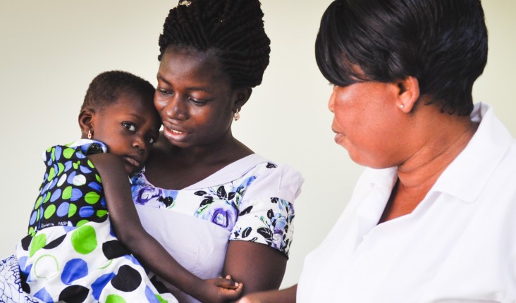 A nurse consults with a mother on her child's health at a USAID nutrition center in the Volta region of Ghana.