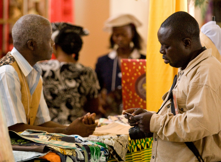 Buyers and artisans conduct business at a trade showcase supported by USAID West Africa Trade Hub. 