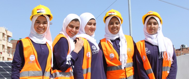 Female students at a vocational student in Hurghada, Egypt stand in front of solar panels.