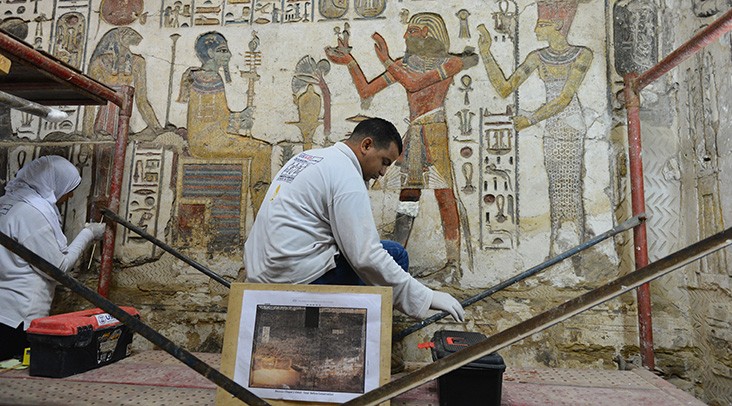 A field school trainee cleans paintings at Khonsu Temple at Karnak