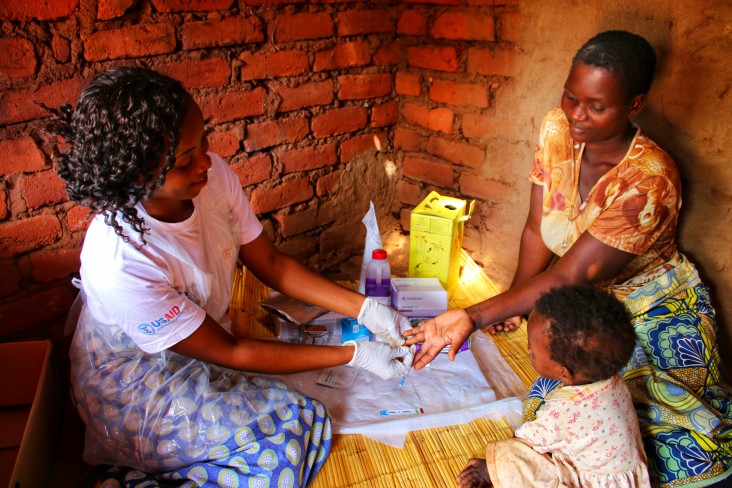 A Community Engagement Facilitator with One Community provides home-based HIV testing service to a woman in rural Machinga, Malawi.