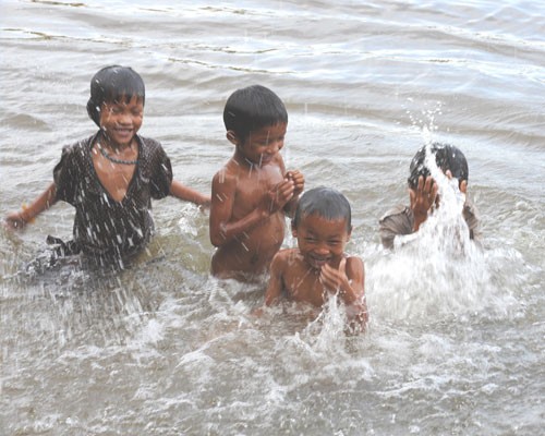 Children play in the Mekong River, a major source of snail fever.