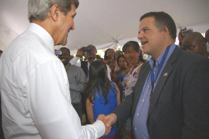 Bryce Smedley speaks with U.S. Secretary of State John Kerry during Kerry’s visit to Kinshasa in April 2014.