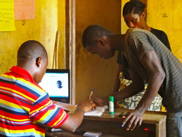 Filling out voter registration paperwork at a voter's registration center in Central Liberia
