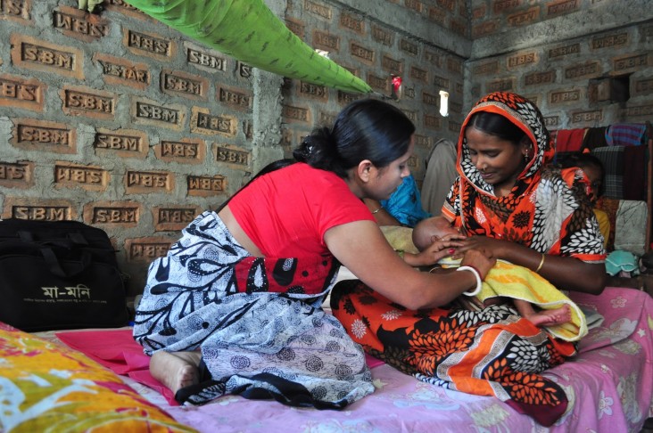 A woman helps a mother with her baby