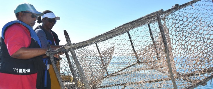 Game warden Venis Bryan and co-captain Cavin Lattibeaudiere remove an illegal fish trap from the Bluefields sanctuary.