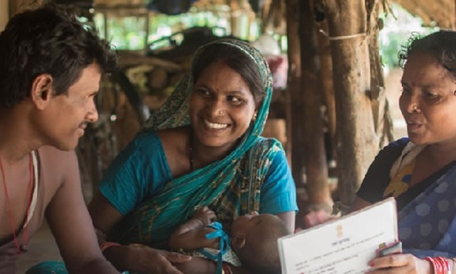 A health worker shares information with a man and a woman.