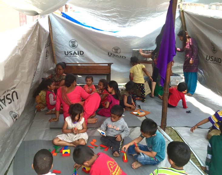 Children attend school in a temporary classroom in Kathmandu built using plastic sheeting.