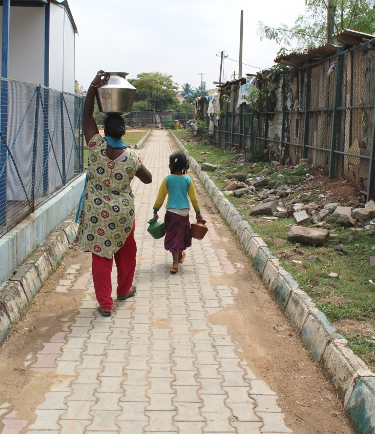 A girl and her mother return home with purified drinking water in Bengaluru’s Lingarajpuram slum.