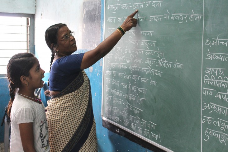 Schoolteacher Jayshree Kopershinde helps her “chatterbox” student, Swati, read sentences.