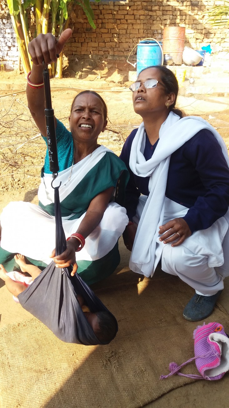An auxiliary nurse midwife, right, observes as a community health worker weighs a newborn at his home in the Haridwar district of Uttarakhand state.