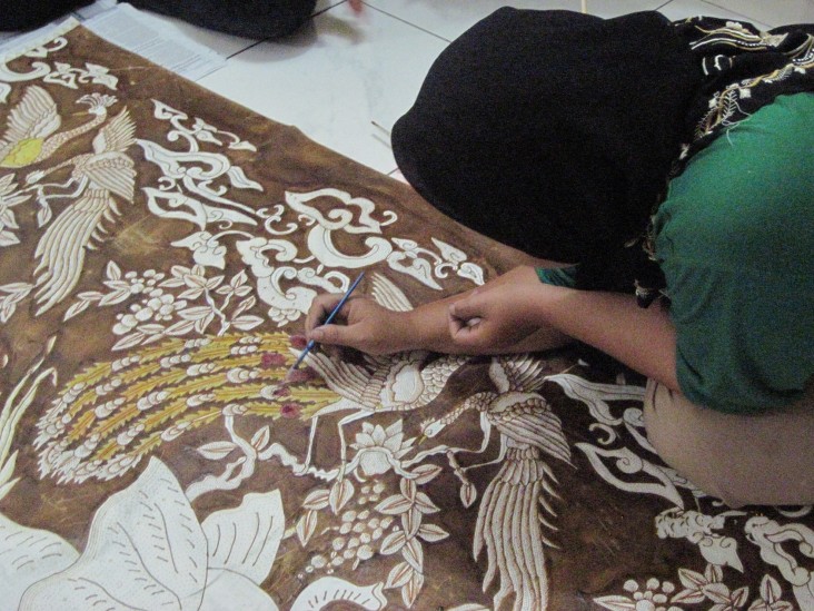 Hamidah paints on batik fabric using a natural dye derived from mangroves.